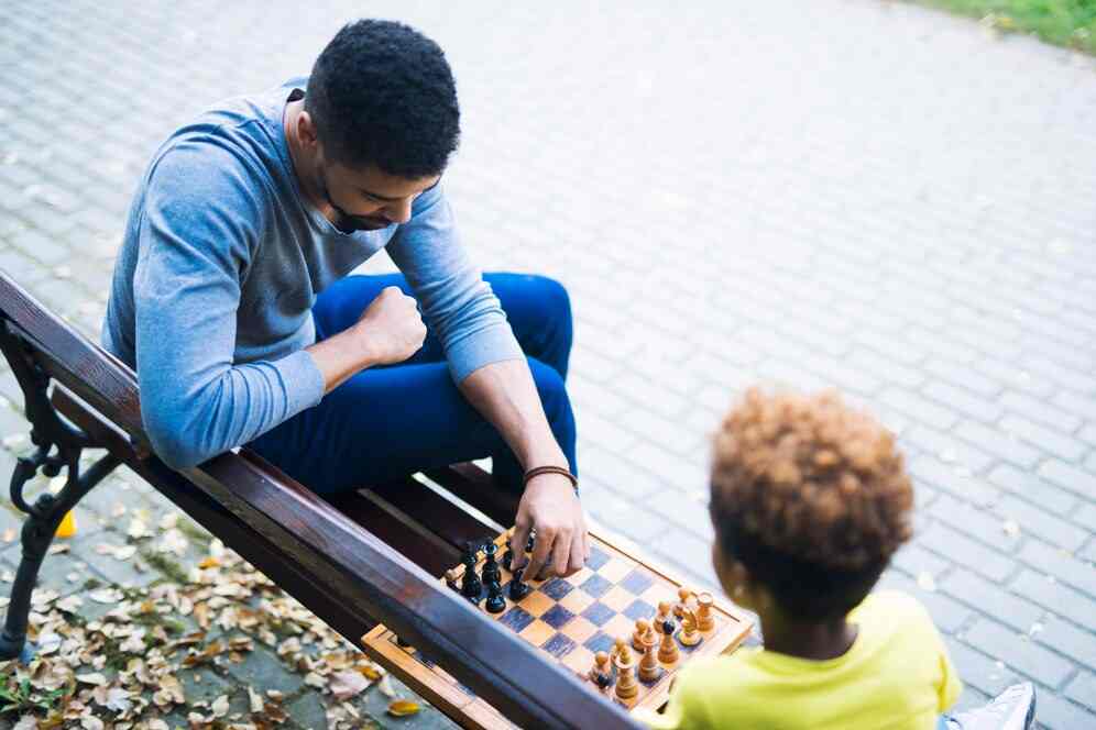 A boy playing chess with a man