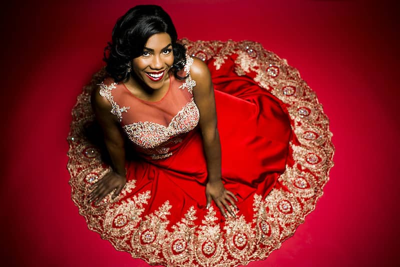 spotcovery-J'Nai-Bridges-smiling-in-a-red-dress