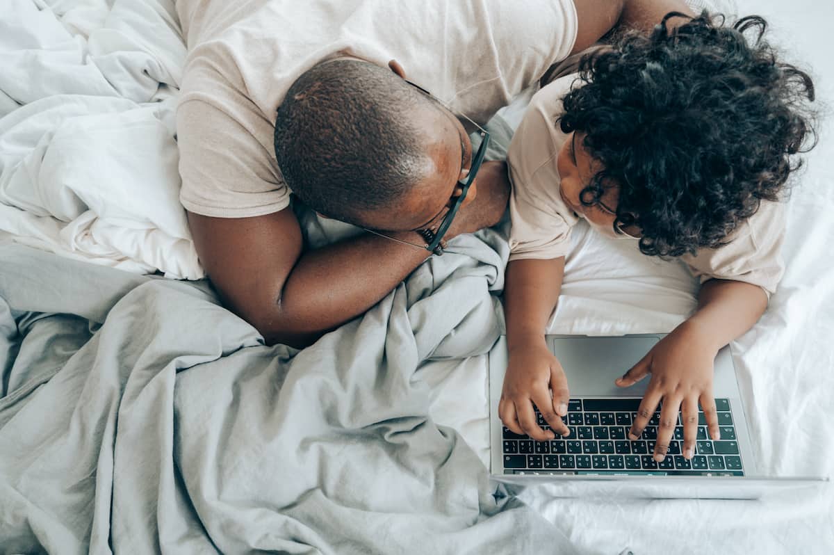 spotcovery-black-guy-and-kid-with-laptop-in-cozy-bedroom-6-money-habits-to-teach-your-kids-as-an-african-american-parent