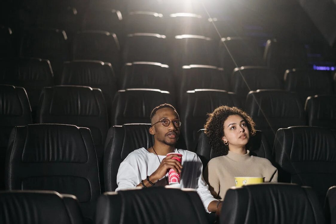 spotcovey-couple-seated-in-a-cinema-theatre-Action Black Movies-Based-on-True-Stories