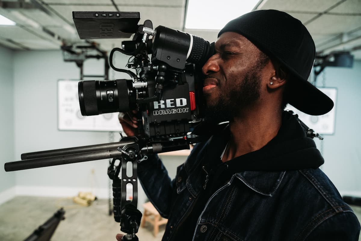 spotcovery-man-in-denim-jacket-holding-black-video-camera-6-essential-steps-for-black-filmmakers-to-monetize-their-videos-online