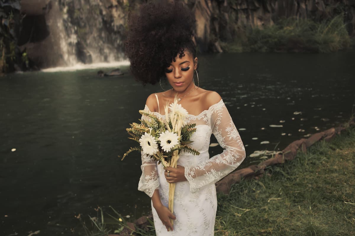 spotcovery-woman-in-a-white-dress-holding-flowers-8-black-owned-bridal-shops-to-support