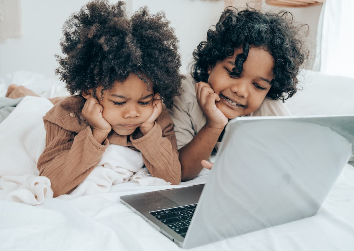 spotcovery-ethnic-little-brothers-using-laptop-on-bed-edutainment-for-little-ones-top-black-educational-shows-for-toddlers