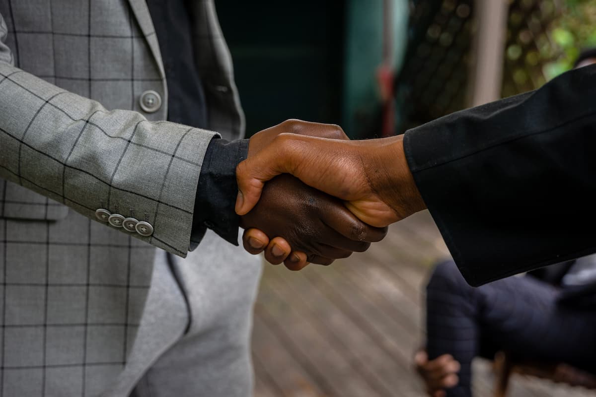 spotcovery-men-in-suit-jackets-shaking-hands-mastering-the-art-of-negotiation-empowering-savings-for-black-consumers