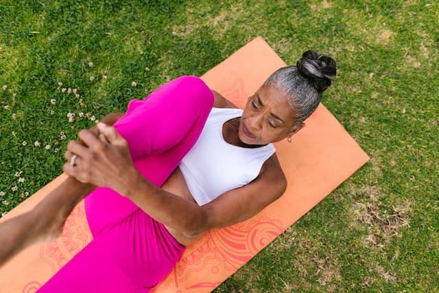 spotcovery-old-woman-in-white-and pink-sitting-on-a-mat-exercisingmuscle-mass-loss-with-age-how-black-people-can-slow-the-process
