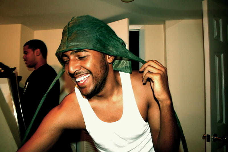 spotcovery-a-young-black-man-smiling-with-his-undone-green-durag