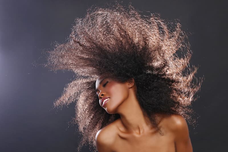 spotcovery-a-woman-wiping-her-big-afro-in-the-air