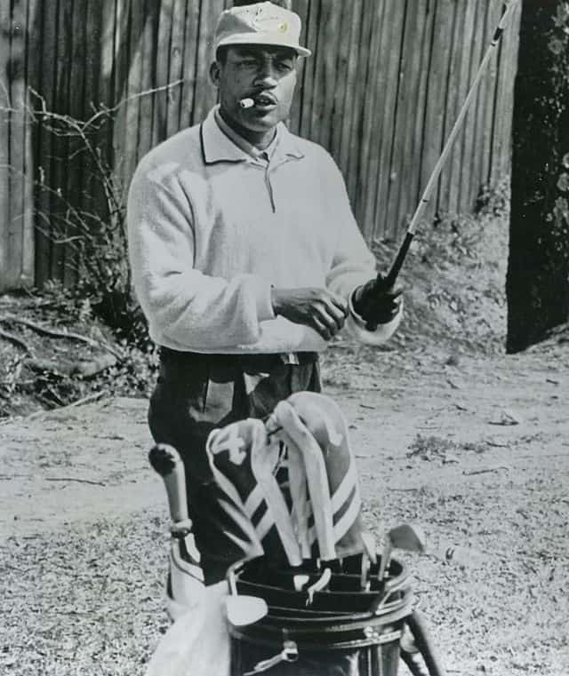 spotcovery-the-first-black-golfer-sifford-standing-beside-his-golf-clubs-charlie-sifford-first-black-golfer-in-the-pga