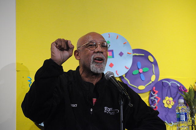 spotcovery-carlos-speaking-at-an-event-and-showing-his-black-salute-john-carlos’-silent-protest-and-his-legacy-in-track-&-field