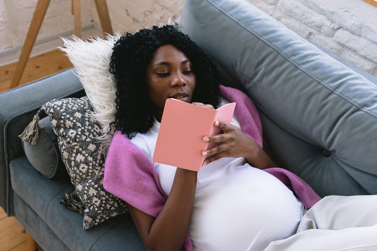 spotcovery-black-pregnant-woman-writing-in-notebook-on-couch-top-6-jobs-for-pregnant-women-you-probably-didn't-know
