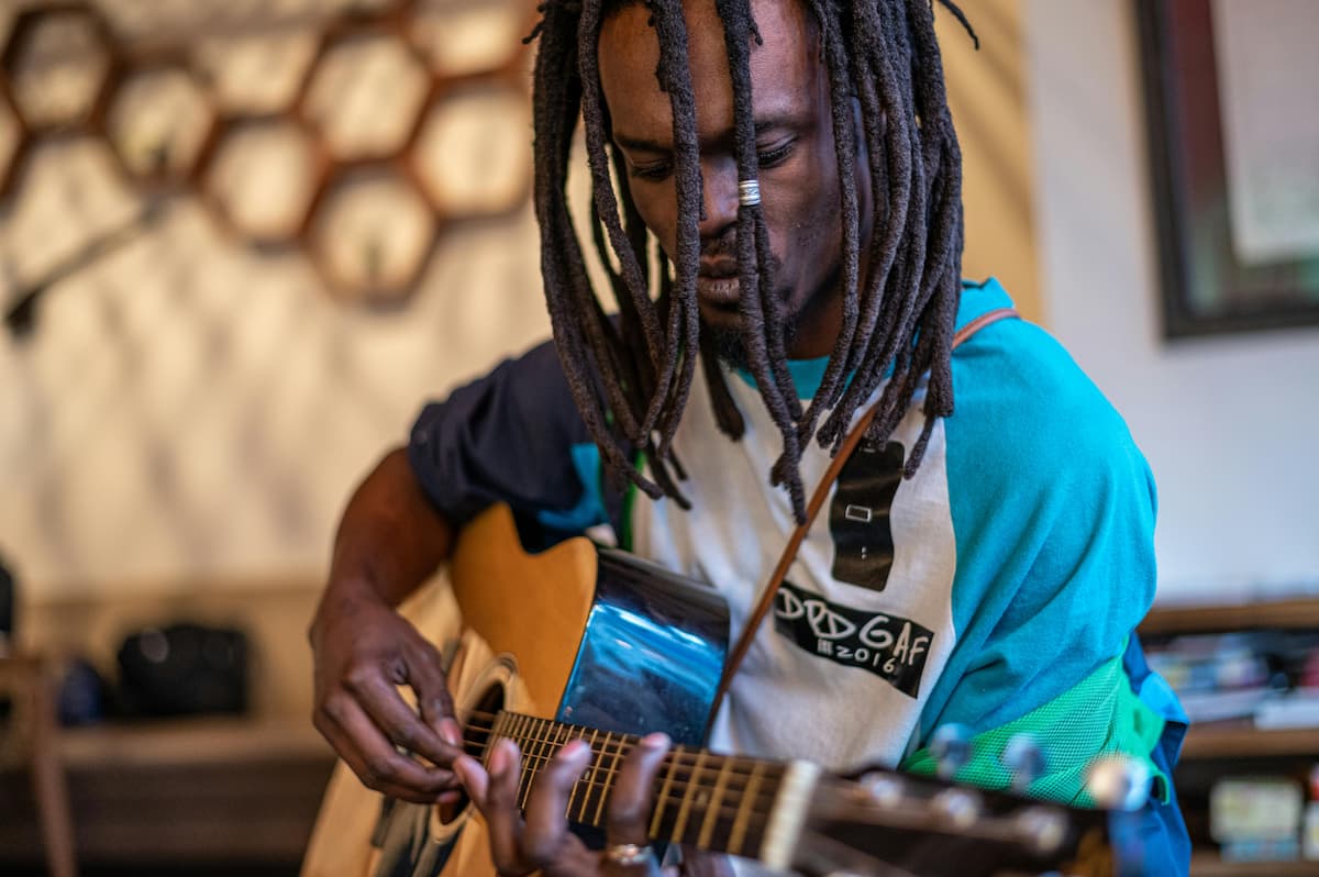 spotcovery-focused-black-man-playing-guitar-in-studio-9-reggae-music-artists-loved-by-black-american-audiences