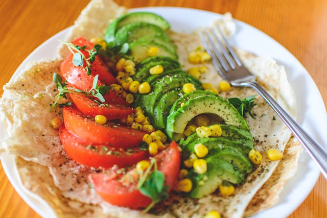 spotcovery-a-plate-of-tomato-corn-meal-and-avocado-layered-on-wrap-celebrating-world-vegan-day-recipes-myths-and-motivation-to-try-veganism